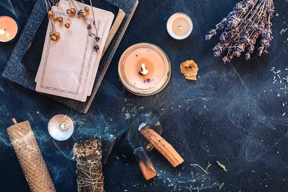 a collection of candles, incense and tarot cards