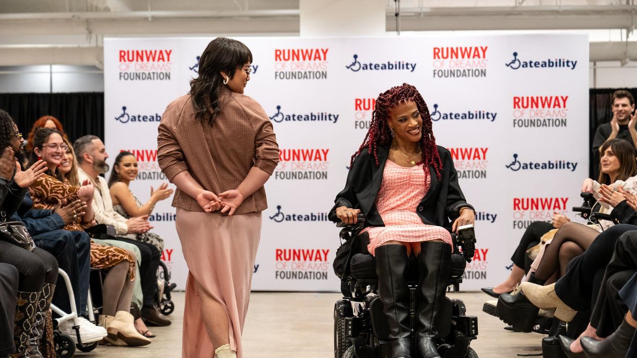 A Disabled LGBTQ+ model showcases Adaptive design at a Runway of Dreams Foundation fashion show.