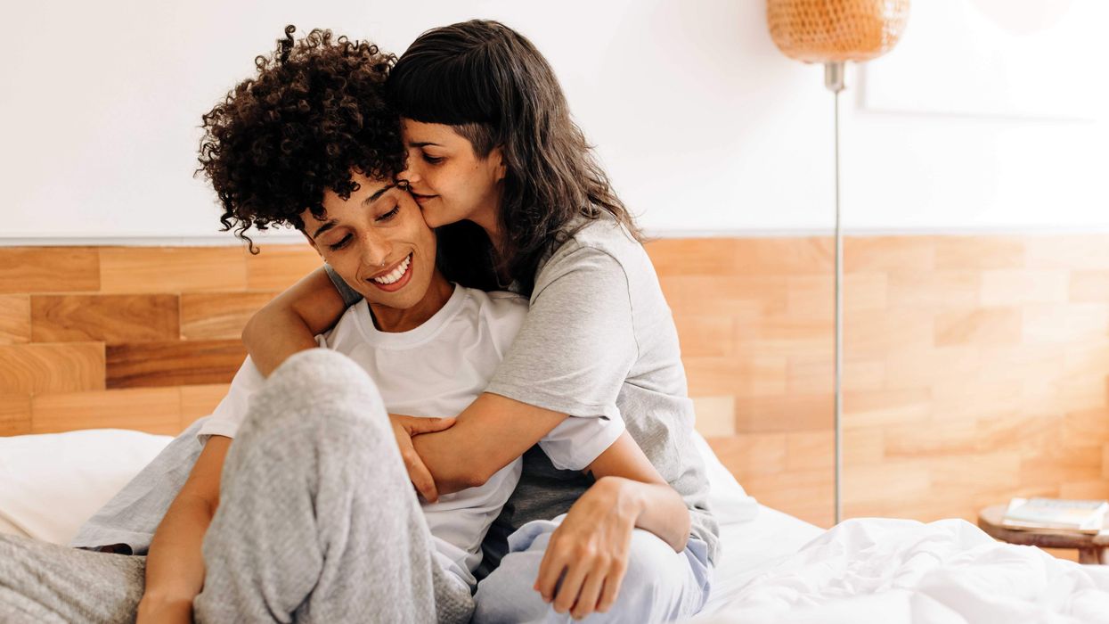 A lesbian hugging another woman from behind