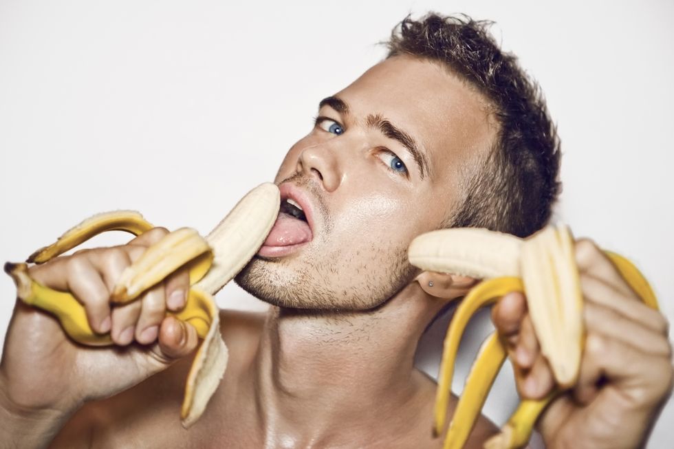 a man seductively eating two bananas