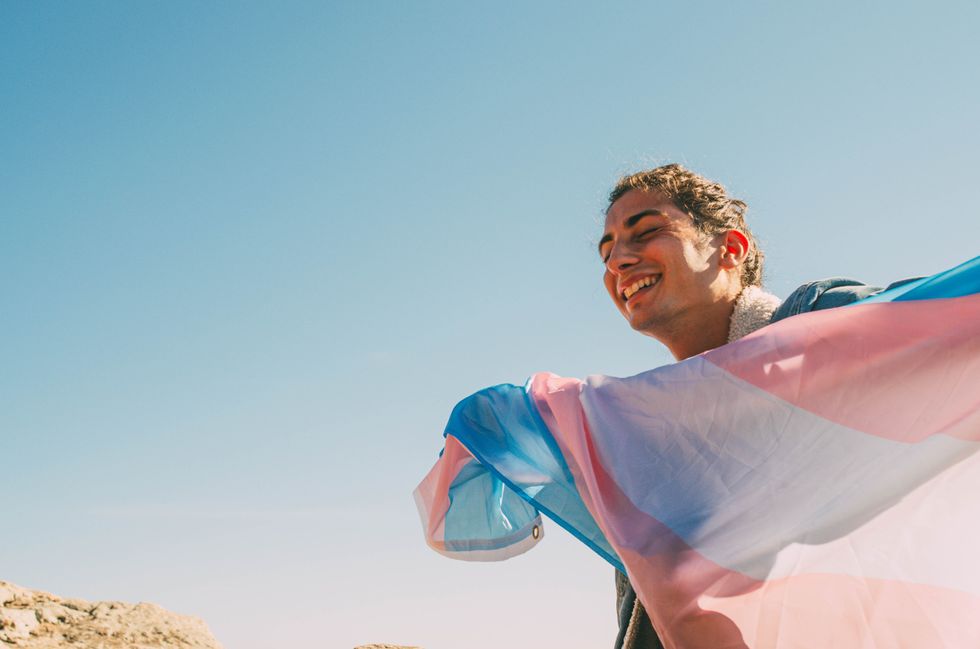 a person holding a trans flag