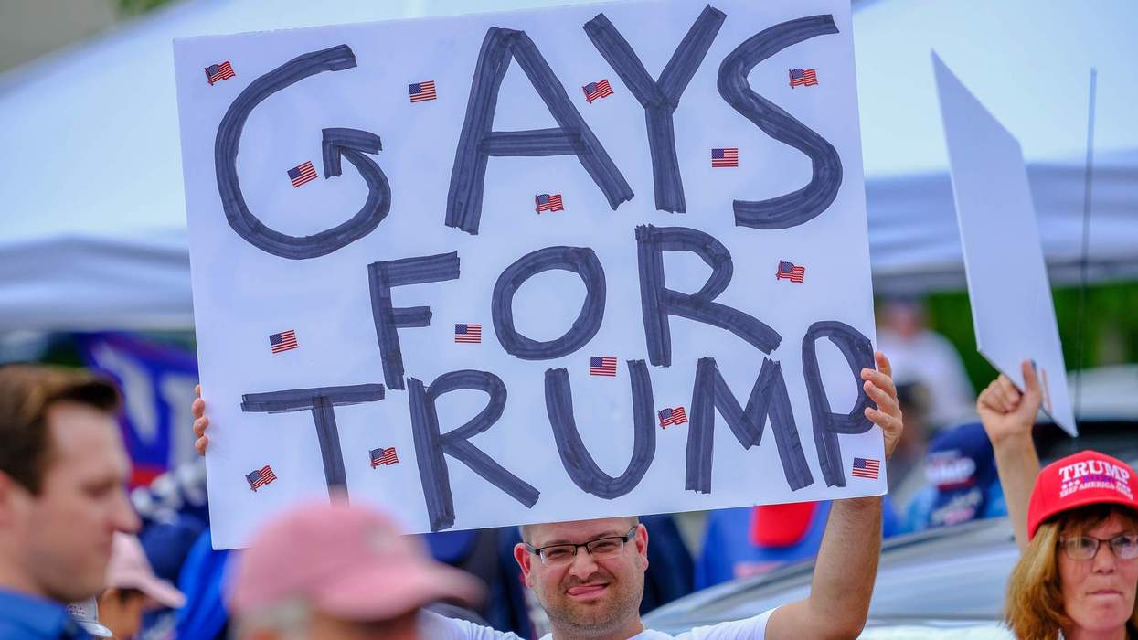 A Trump supporter holds a Gays for Trump, placard in New Hampshire