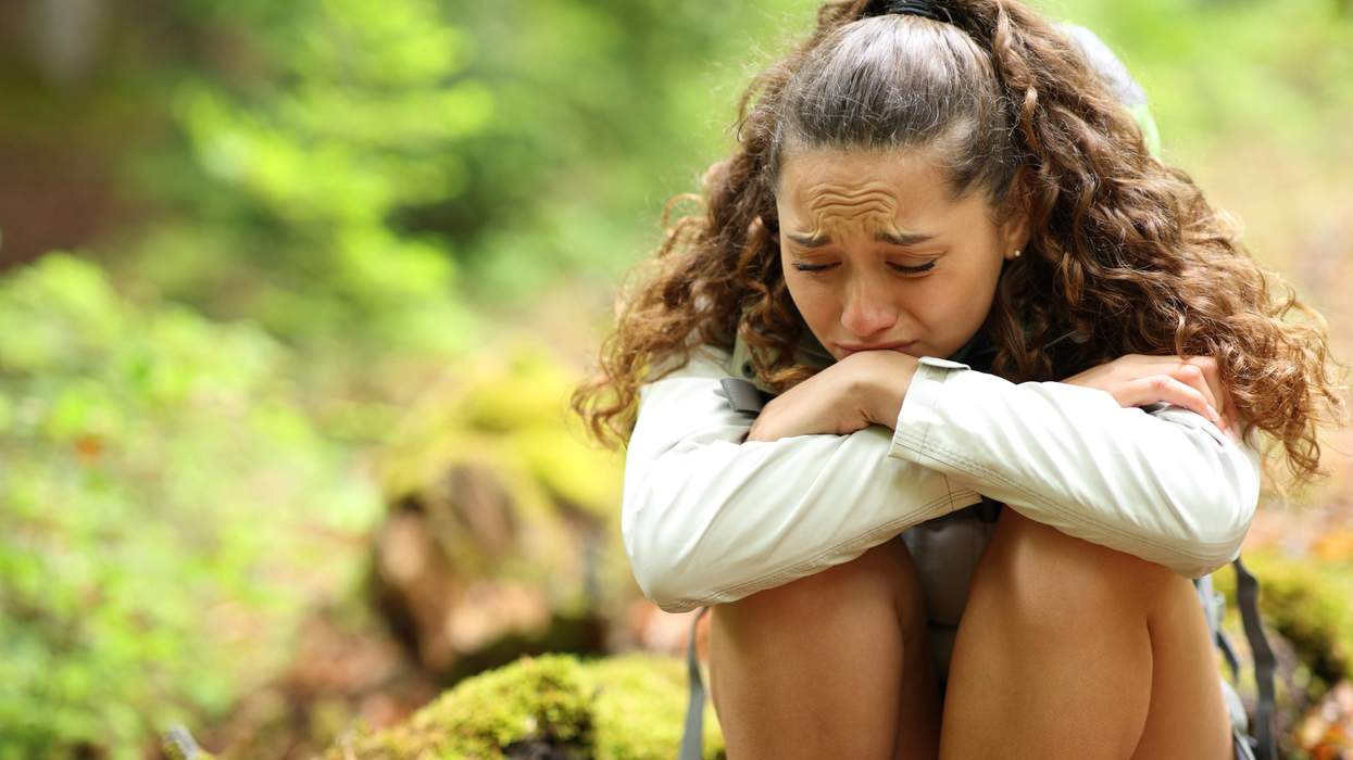 A woman crying while sitting outdoors