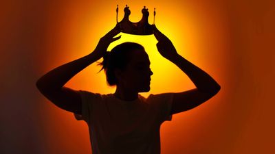 A woman holding a crown over her head