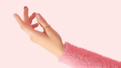 a woman's outstretched arm wearing a pink sweater