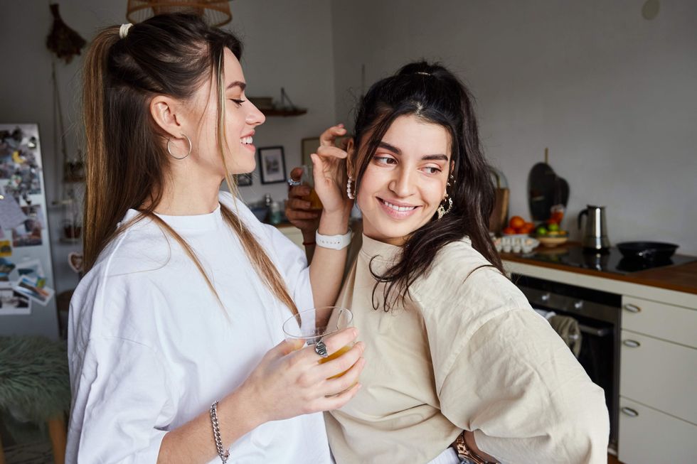 a woman touching another woman's hair