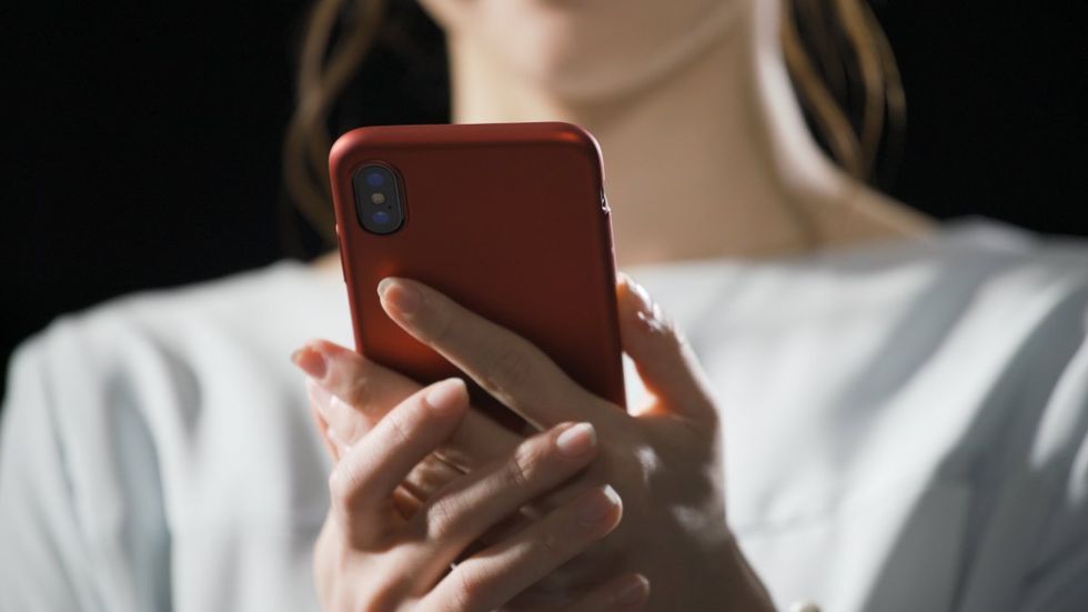 A young woman is operating a smartphone