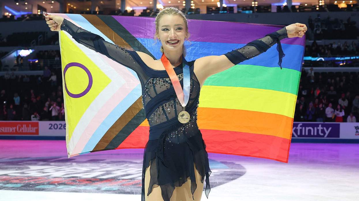 Amber Glenn holding a Progress Pride flag