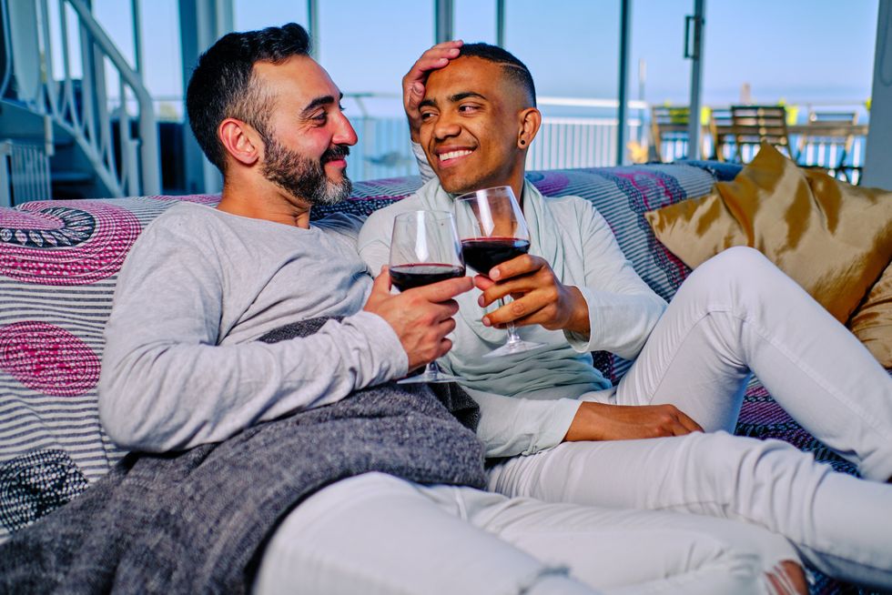 an interracial gay couple drinking wine