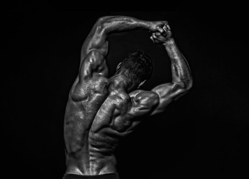 built man in black and white photo showing his back