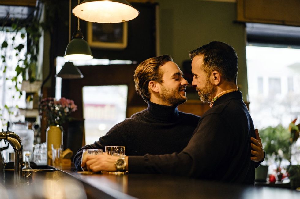 Couple in embrace at bar looking into each others eyes