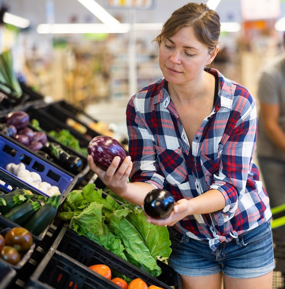 cute girl in the supermarket wearing a plaid flannel shirt and jeans shorts selecting produce photo gallery listicle Lesbians reveal the spiciest things on their sexual bucket list