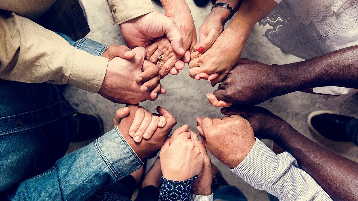 diverse group of hands holding each other in a healing circle