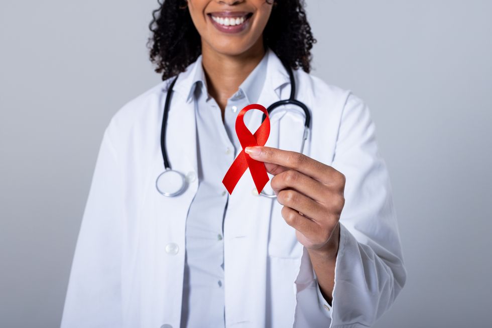 doctor holding hiv red ribbon