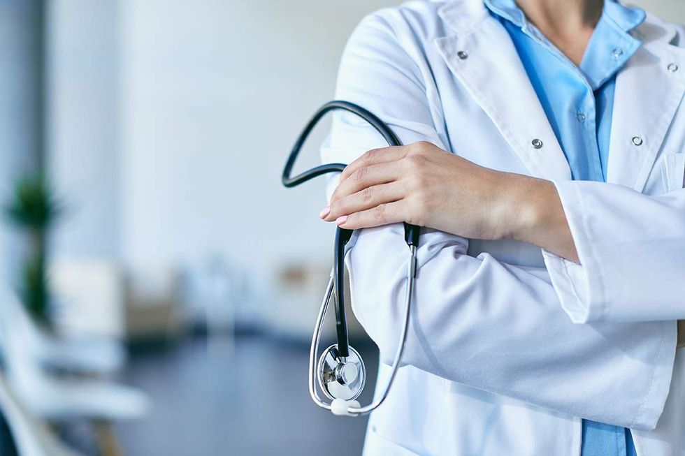 Doctor in a white coat holding a stethoscope.