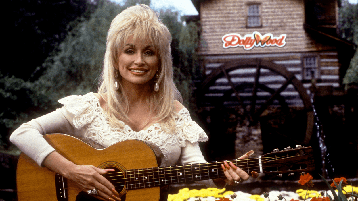 Dolly Parton poses for a portrait with her guitar at Dollywood circa 1993 in Pigeon Forge, Tennessee.