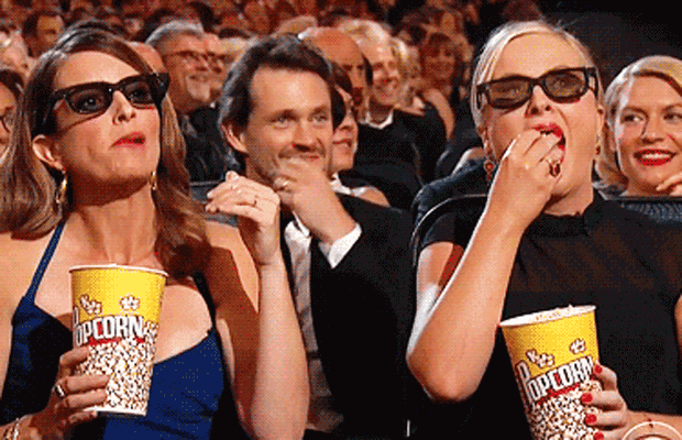 Fey and Poehler watching with popcorn gif
