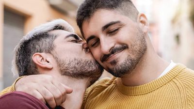 Gay man kissing another man's cheek