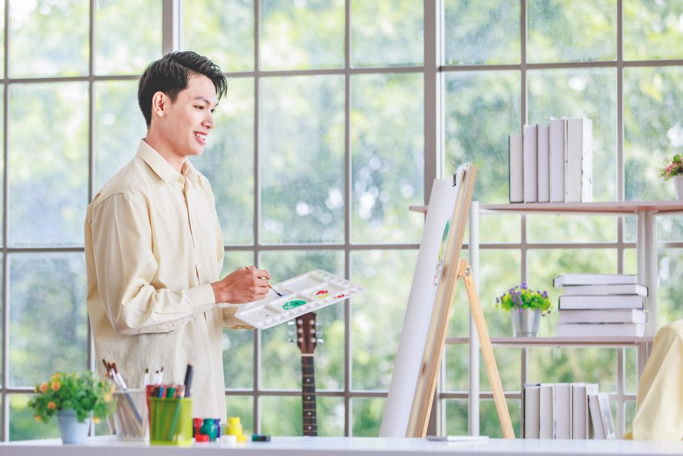 gay man painting on an easel