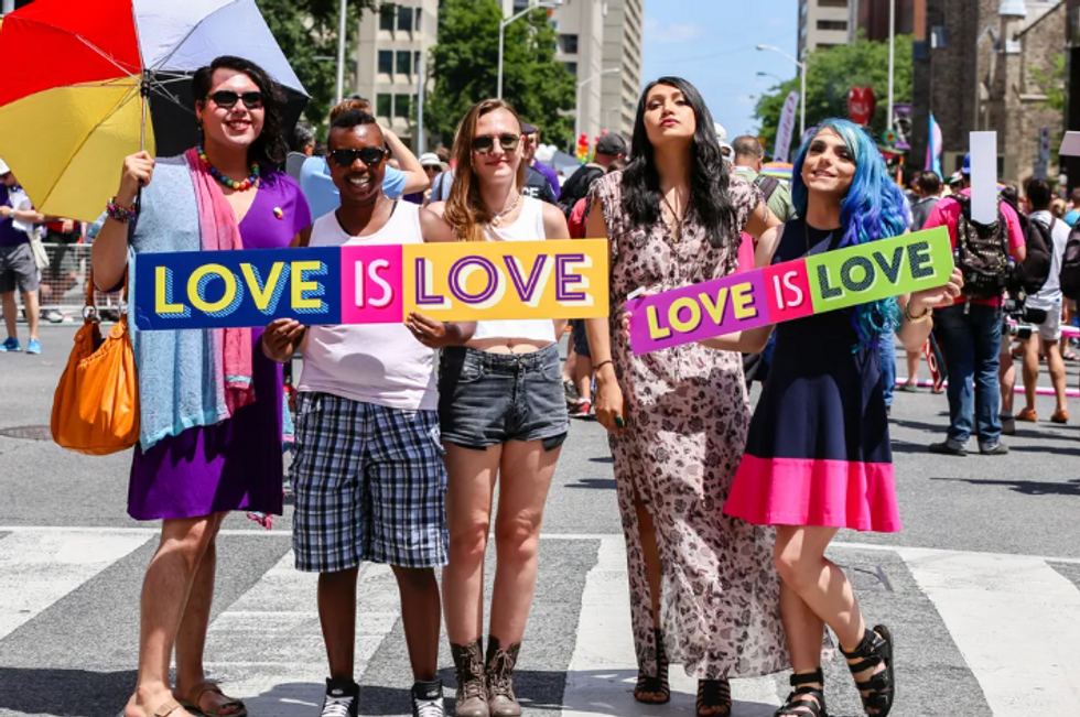 group of people holding love is love signs