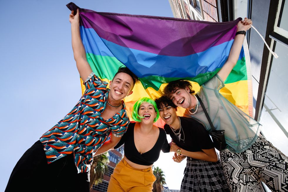 group of people under a queer flag