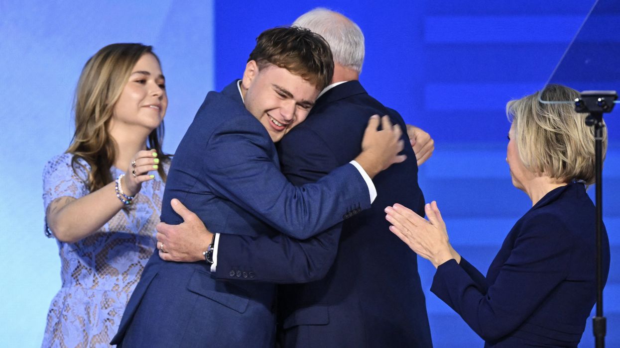Gus Walz hugs his father Tim Walz on stage at the Democratic National Convention