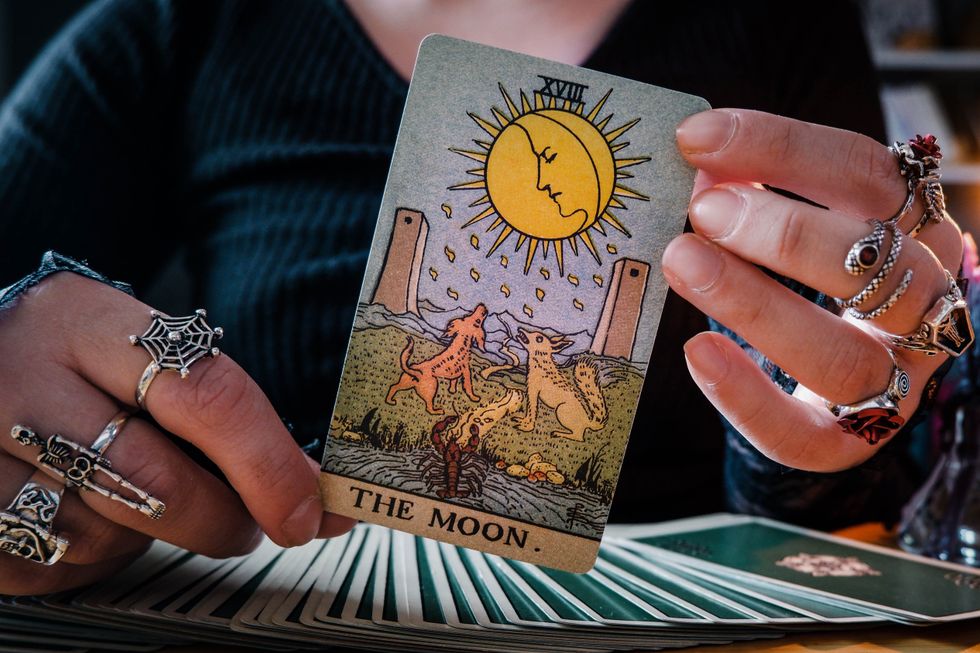 Hands holding up a tarot card