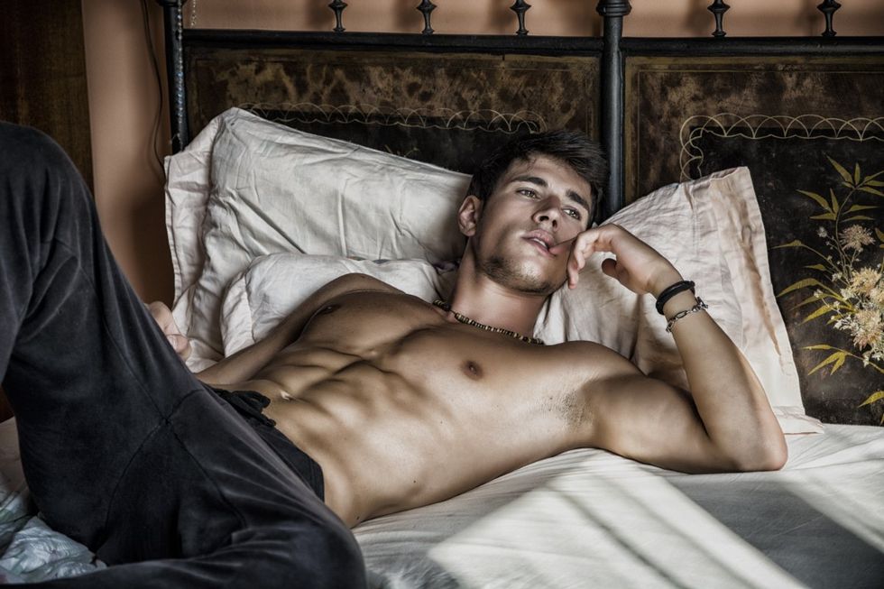 handsome shirtless gay man in bed