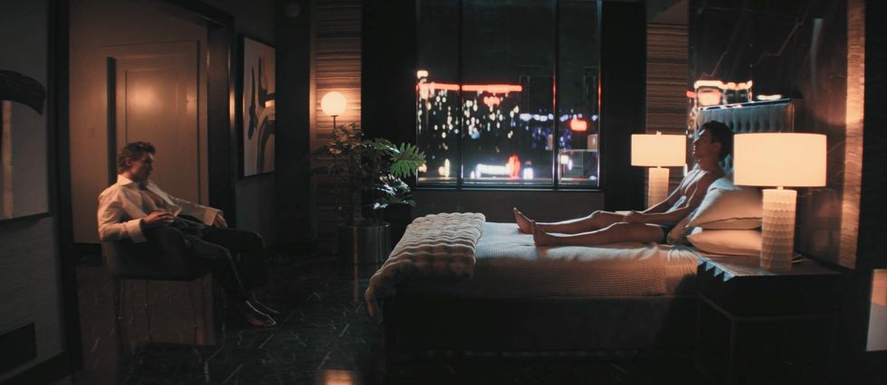 Ilya watches Shane from across the room