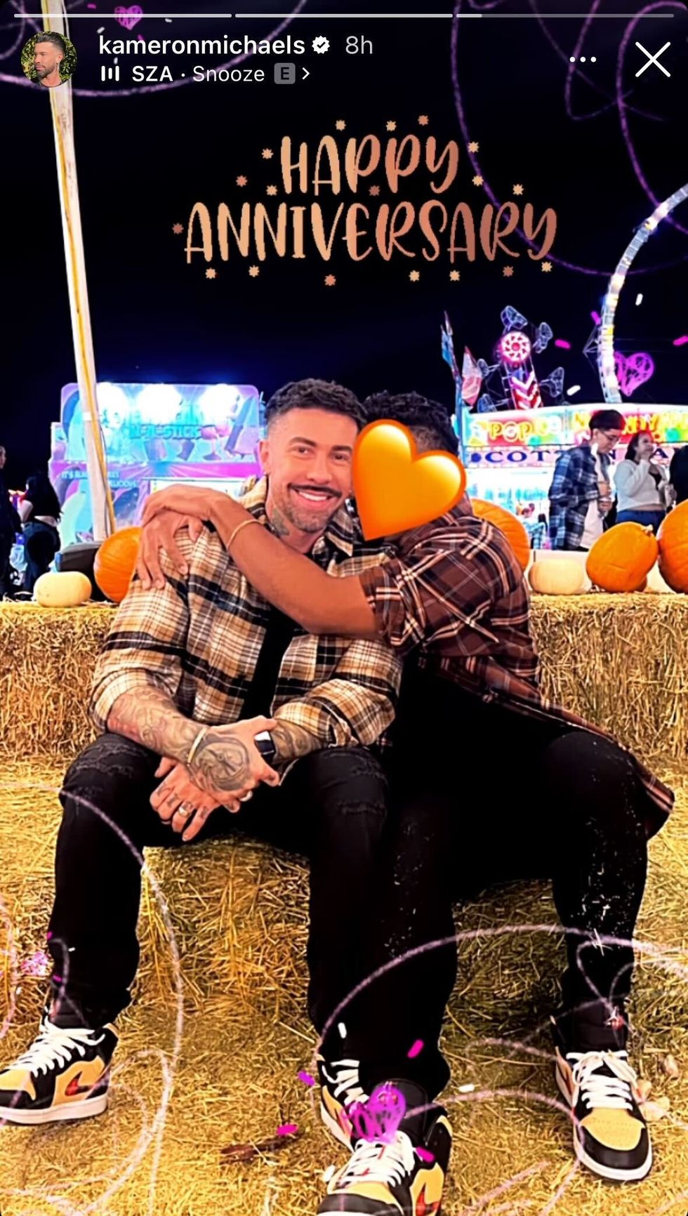 Kameron Michaels sitting on a hay bale with his new boyfriend.