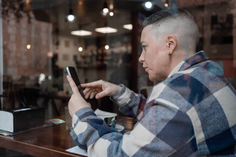 Lesbian looking at a cell phone while at a cafe