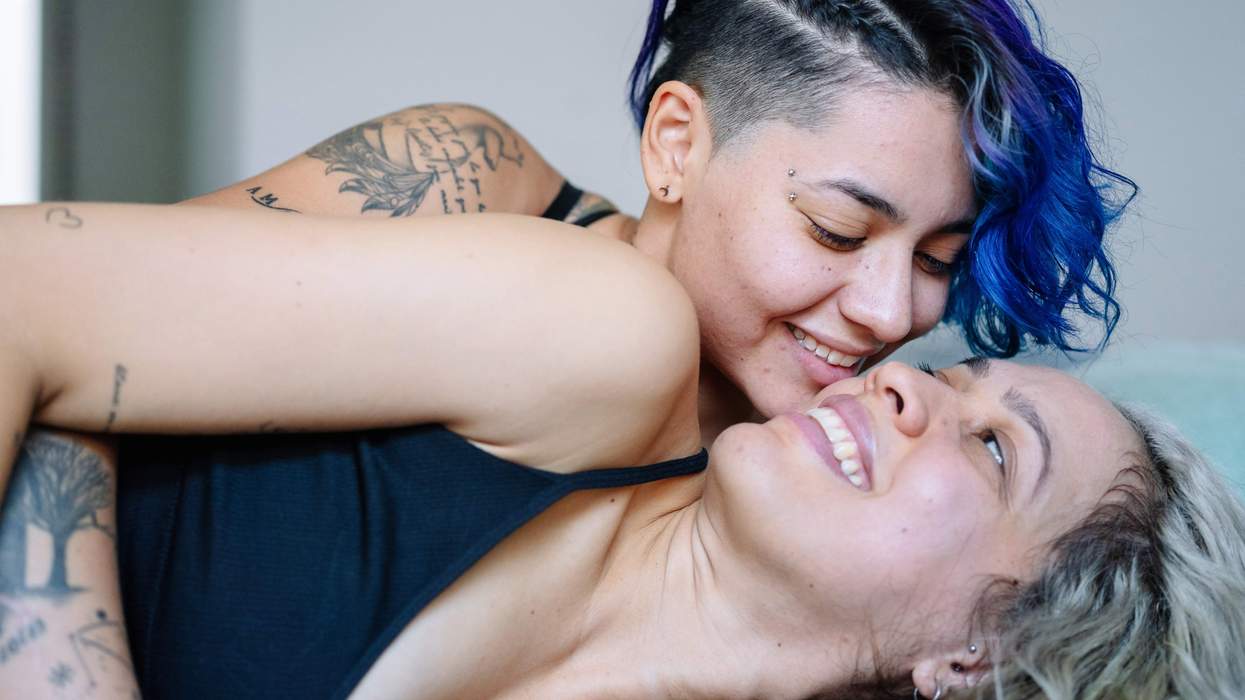 Lesbians cuddling and smiling, symbolizing strap burn