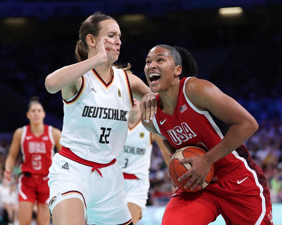 LILLE, FRANCE - AUGUST 04: Alyssa Thomas #14 of Team United States drives past Emily Bessoir #22 of Team Germany during a Women's basketball Group Phase - Group C game between the United States and Germany on day nine of the Olympic Games Paris 2024 at Stade Pierre Mauroy on August 04, 2024 in Lille, France. (Photo by Gregory Shamus/Getty Images)