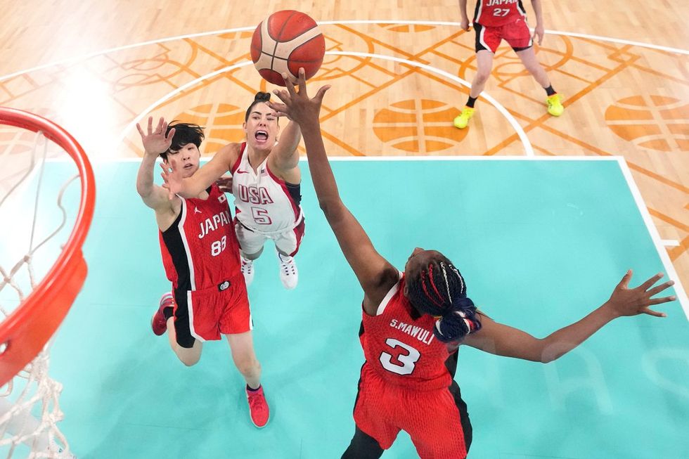 LILLE, FRANCE - JULY 29: (EDITORS NOTE: Image was captured using a remote camera positioned above the field of play) Kelsey Plum #5 of Team United States shoots over Himawari Akaho #88 and Stephanie Mawuli #3 of Team Japan during the Women's Group Phase - Group C game between Japan and United States on day three of the Olympic Games Paris 2024 at Stade Pierre Mauroy on July 29, 2024 in Lille, France. (Photo by Pool/Getty Images)