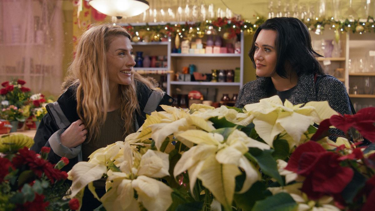 Lindsay Hicks and Rivkah Reyes standing behind flowers in 'A Holiday I Do'