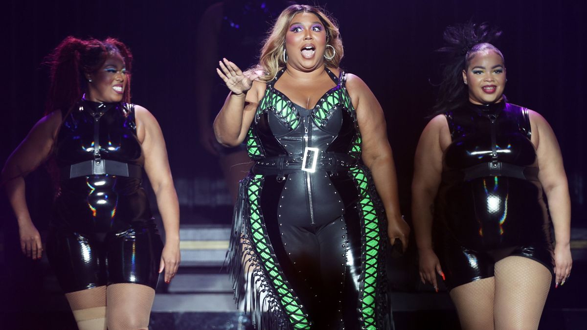 Lizzo on stage with two backup dancers