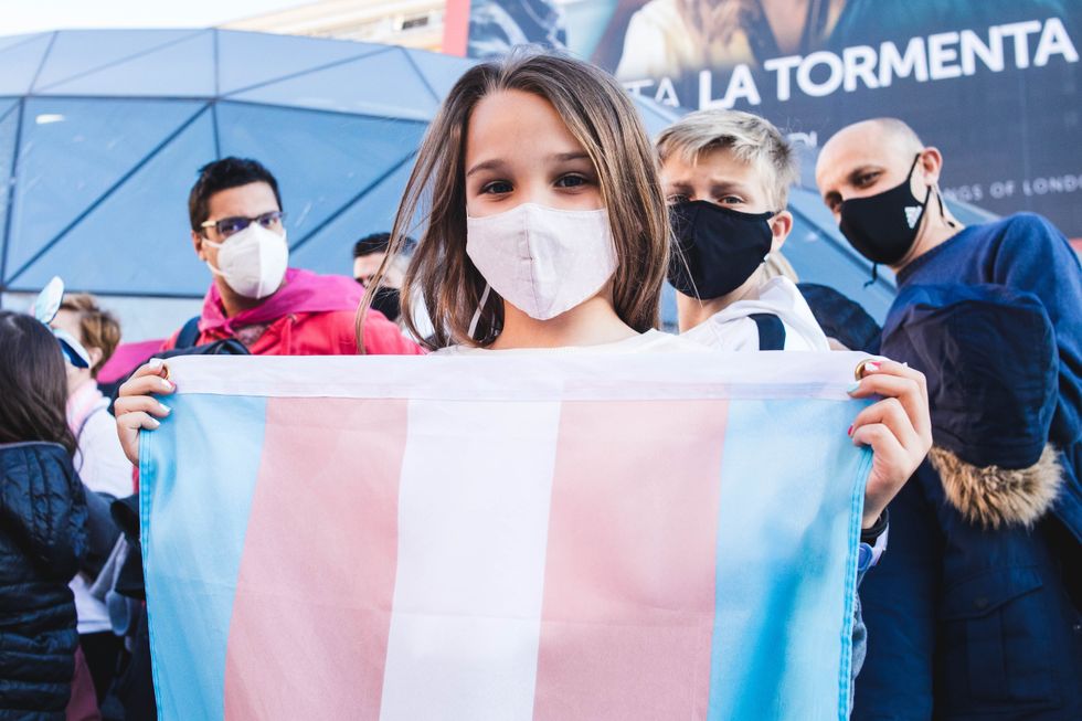 MADRID, SPAIN - MARCH 14, 2021: Protestor holds a trans flag during a demonstration to demand the approbation of the Trans Law in Spain