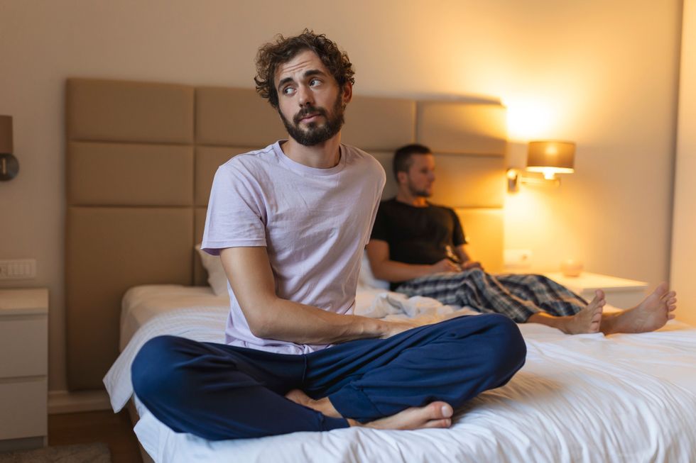 man contemplating in bed