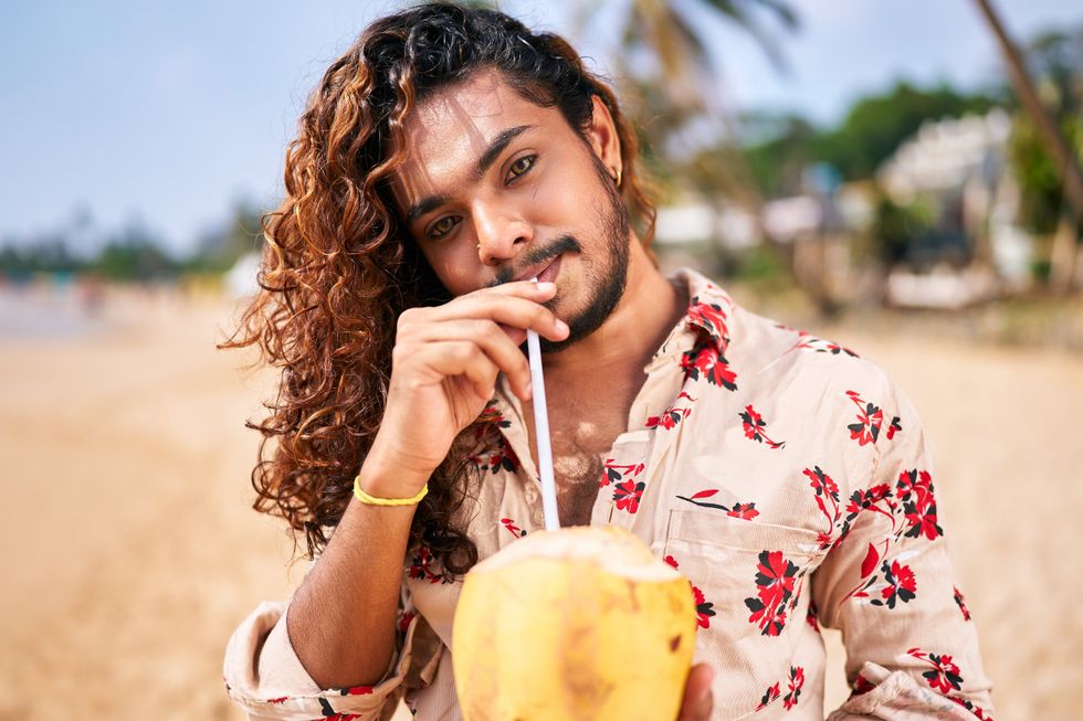 Man drinking from a coconut