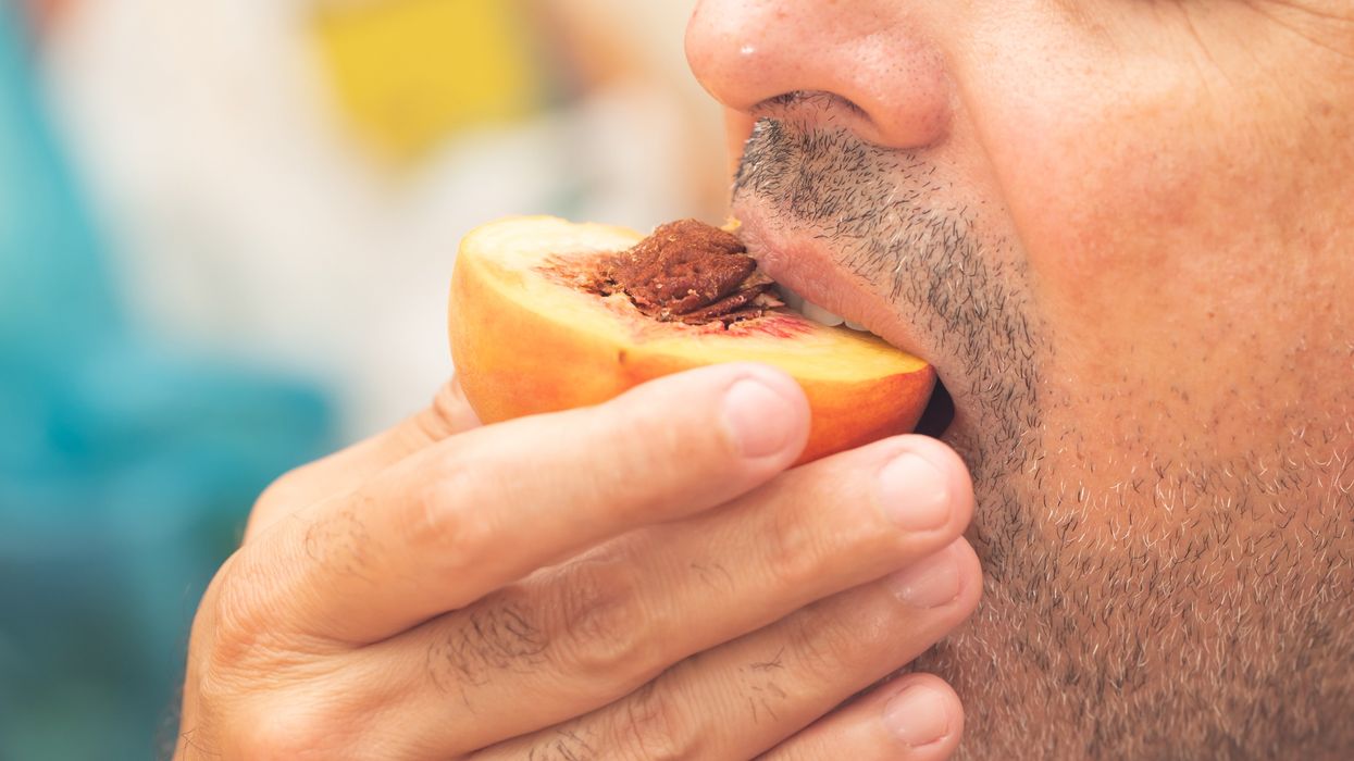 Man eating a peach