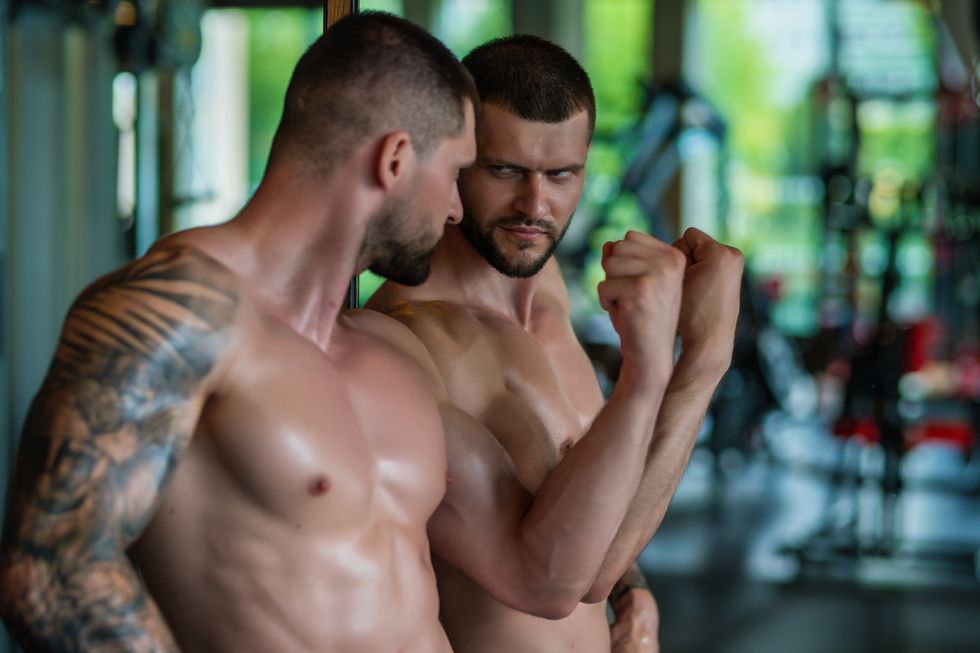 man flexing in a mirror and checking himself out