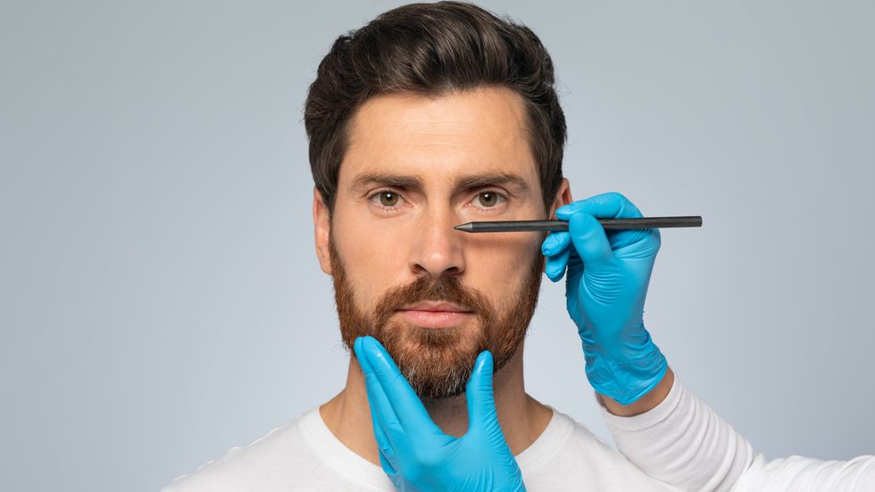 man having nose marked by cosmetic surgeon