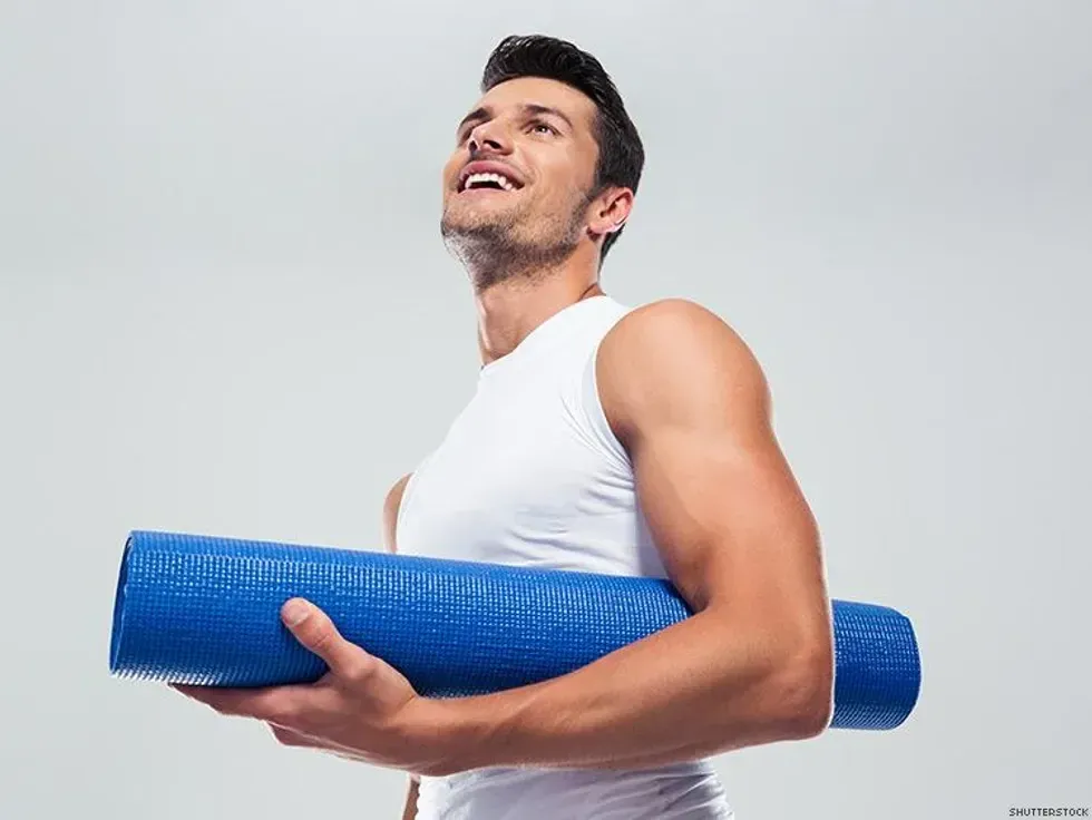 man holding a yoga mat
