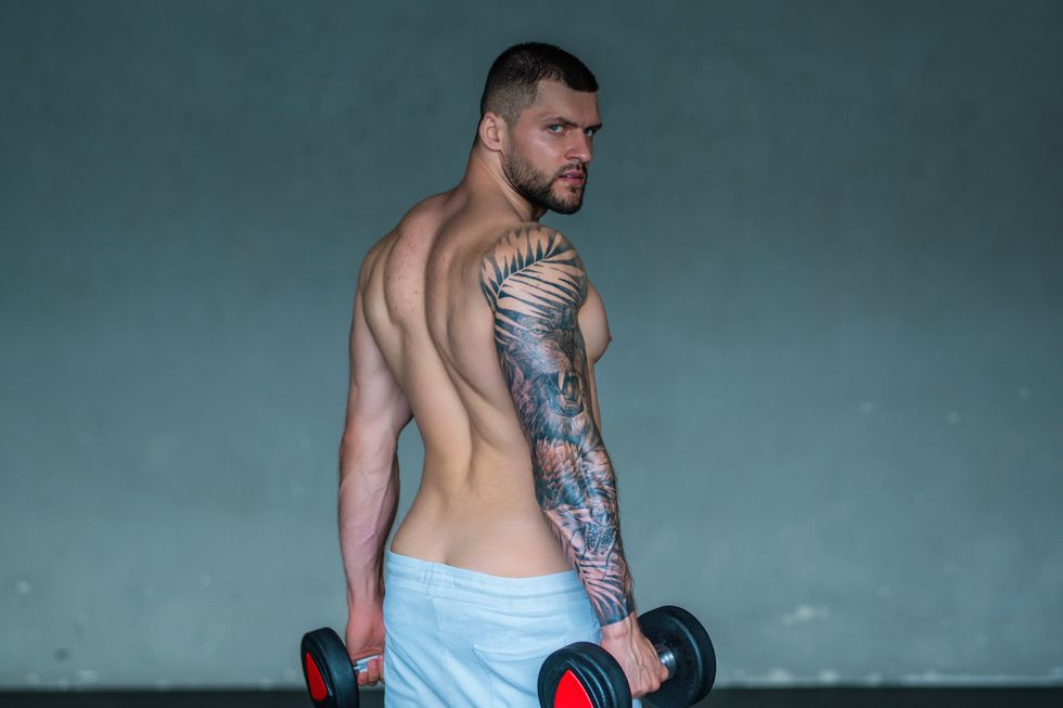 man holding weights and showing his back