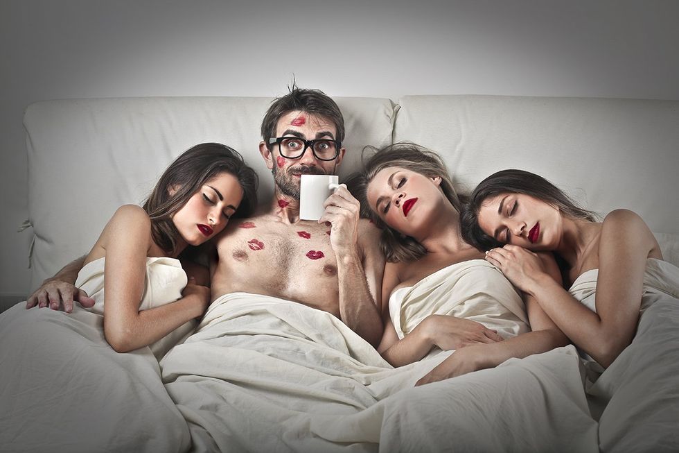 man in bed with three women