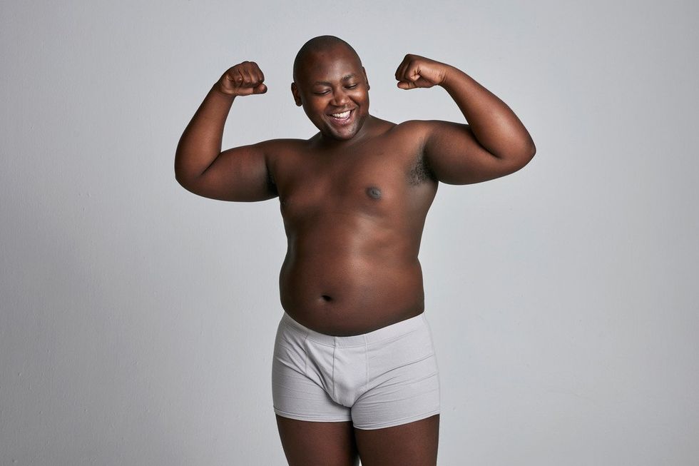 man in underwear flexes and smiles
