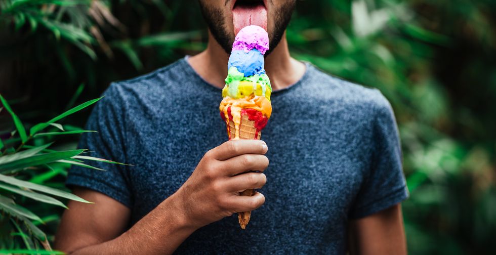man licking a rainbow popsicle
