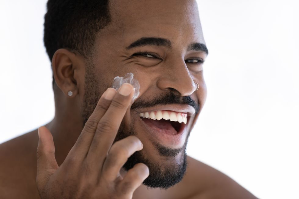 man moisturizing his face