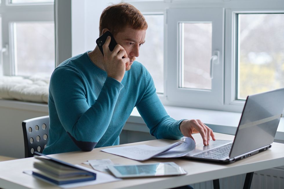 man on his phone and computer simultaneously