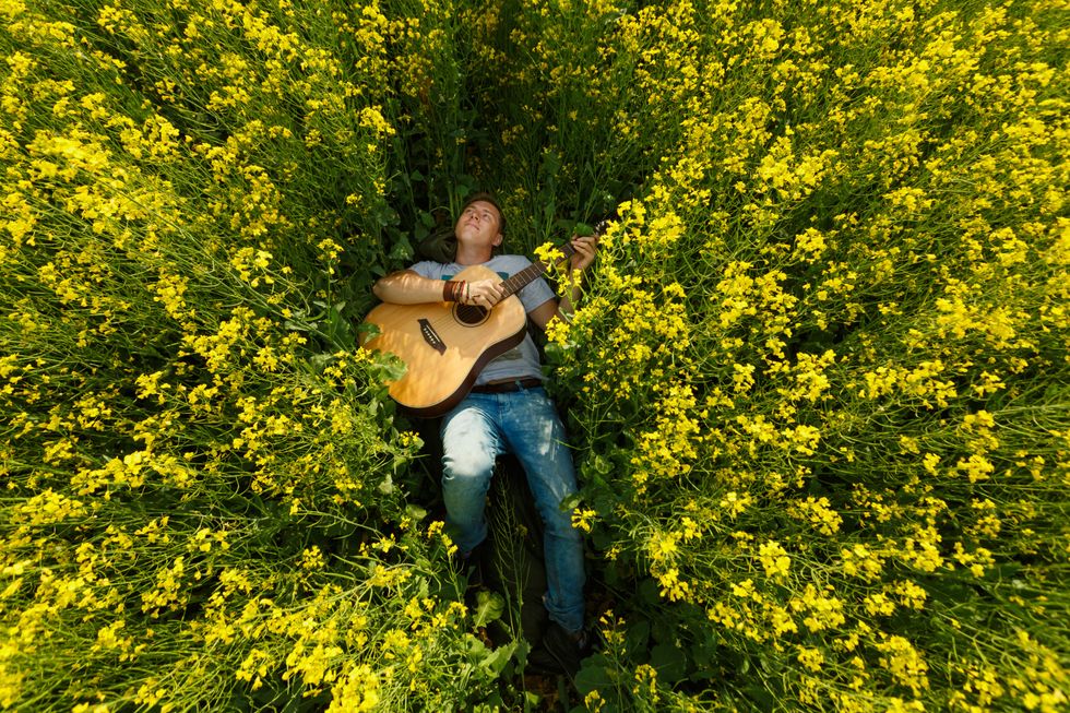 man playing guitar in field